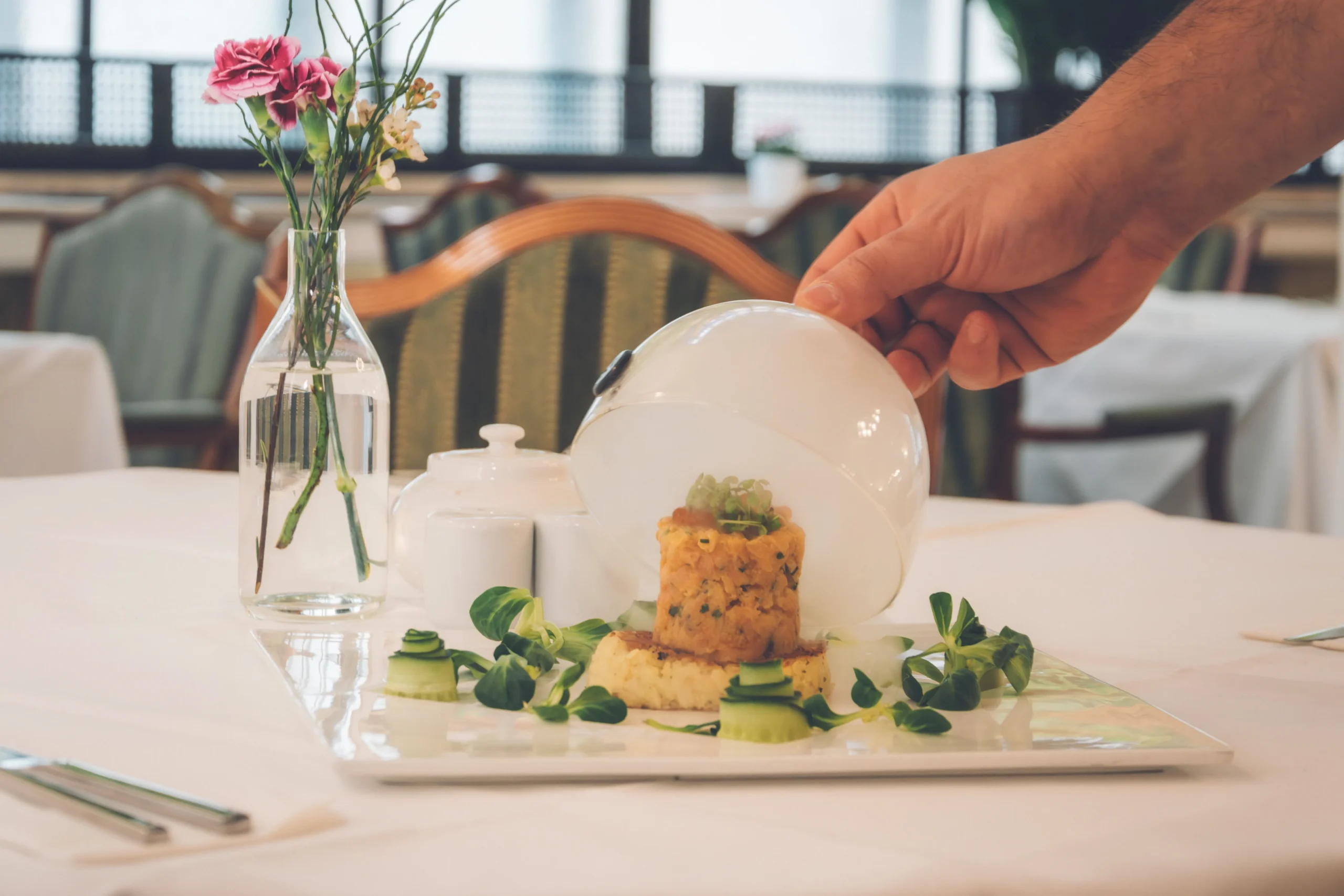 Edle Speisenpräsentation unter Glashaube im Restaurant derFerdinand Baden mit kunstvoll arrangiertem Gericht
